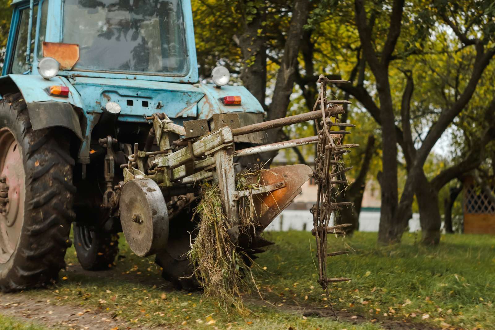 Agricultural tractor fitted with a rake attachment adapted for landscaping work
