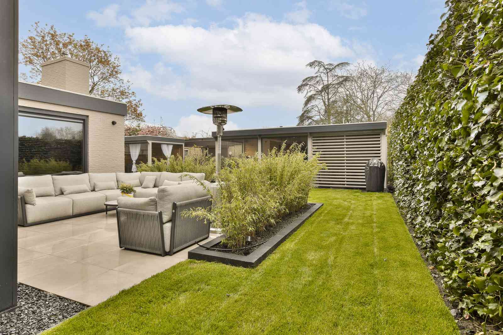 Minimalist garden design with clean lines contrasted against dense greenery