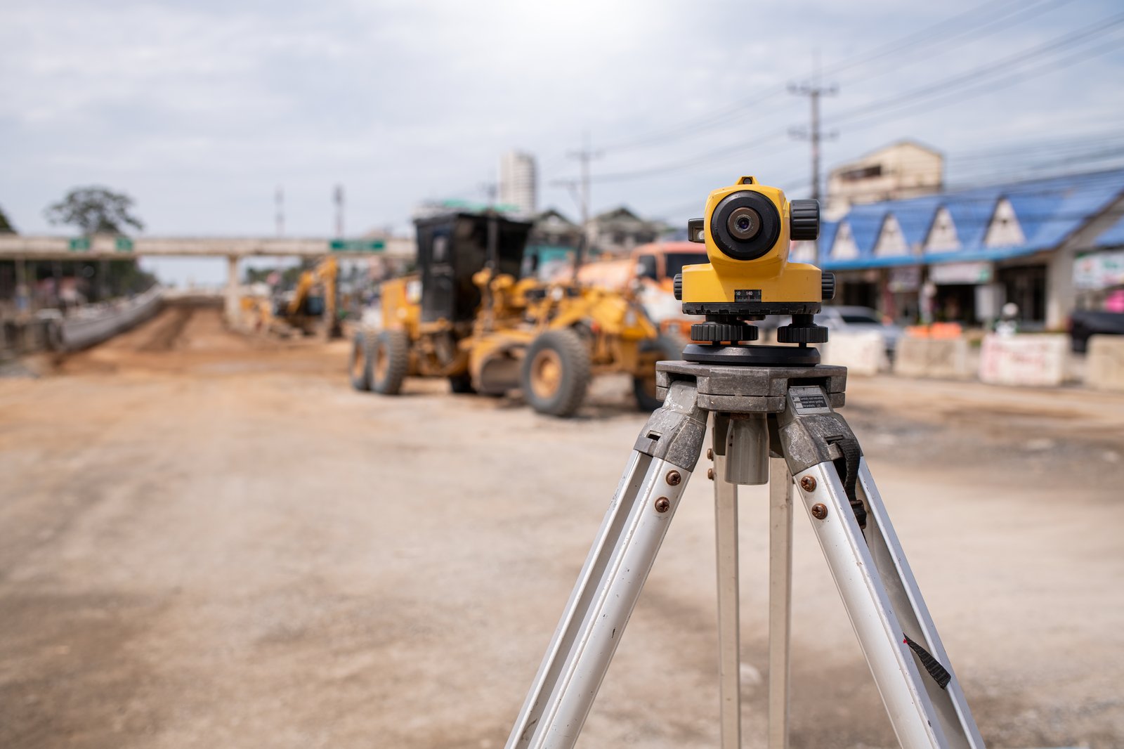 Surveying and positioning equipment guiding heavy machinery at a landscaping construction site