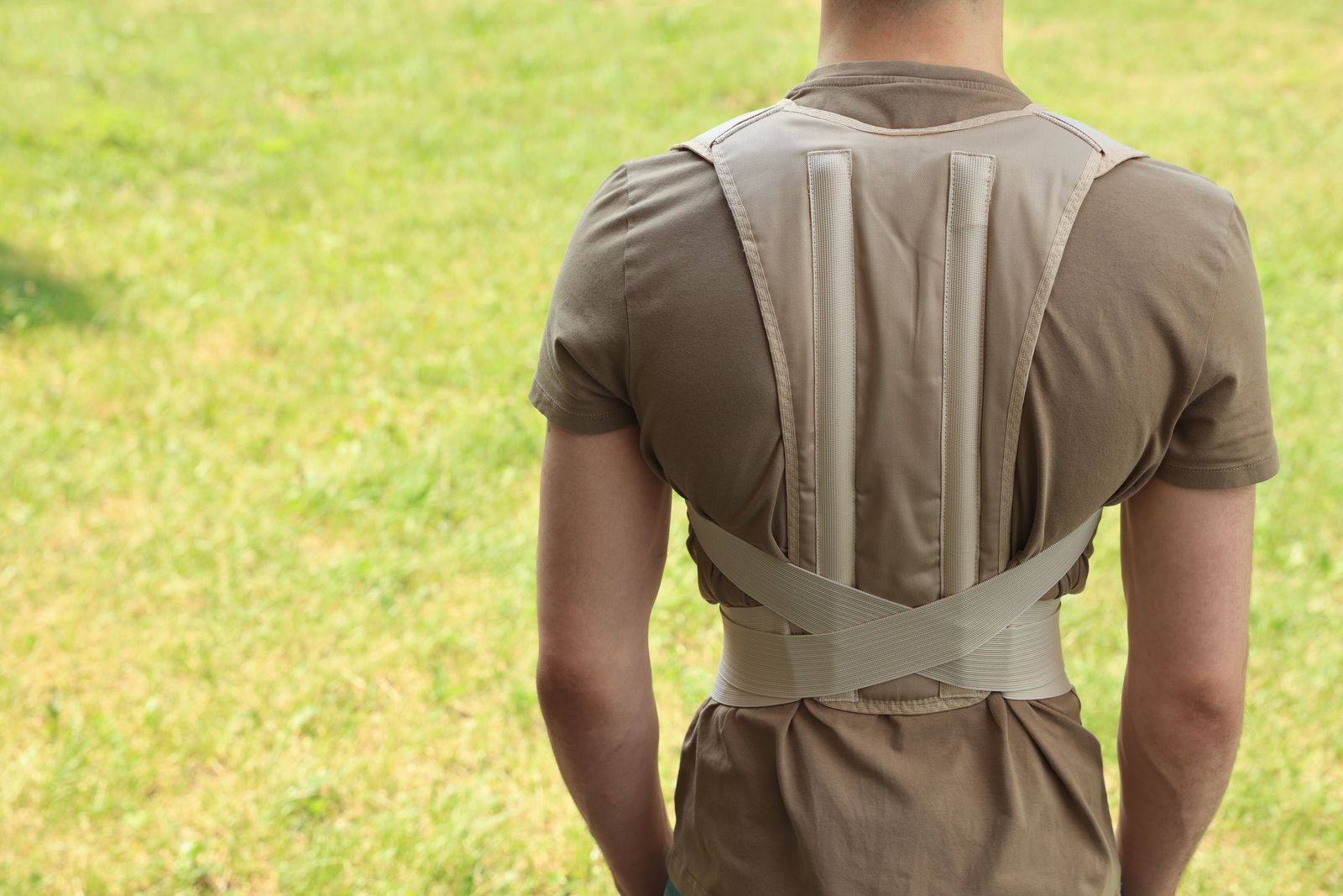 Support brace worn by a landscape worker to reduce strain during physical tasks