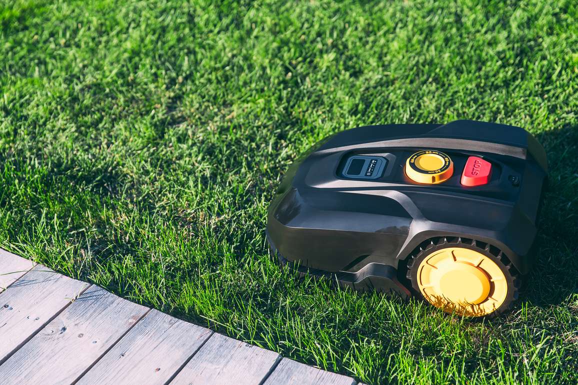 Autonomous robotic mower crossing a residential lawn unattended